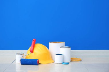 Renkli duvarın yanında boya, paten ve şapka kutuları.