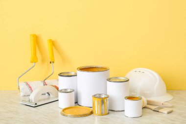 Renk duvarının yanındaki masada boya ve araç gereç kutuları