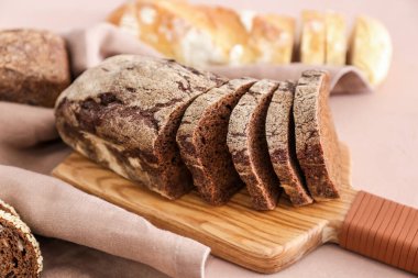 Renkli arka planda taze kesilmiş ekmeğe sahip tahta