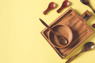 Ahşap kaşıklar, arka planda kâse ve yemek.