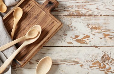 Hafif ahşap arka planda kaşıklar ve kesim tahtaları