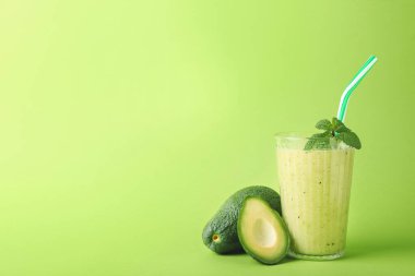 Sağlıklı yeşil smoothie ve avokado renkli arka plan