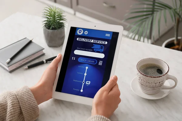 自宅で宅配サービスのアプリケーションのオープンページを持つタブレットコンピュータを保持女性 — ストック写真
