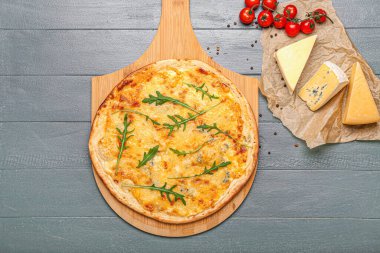 Renkli ahşap arka planda lezzetli peynirli pizza.
