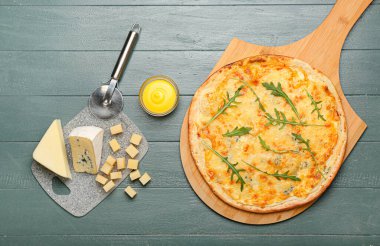 Renkli ahşap arka planda lezzetli peynirli pizza.