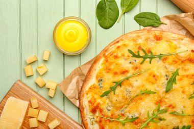 Renkli ahşap arka planda lezzetli peynirli pizza.