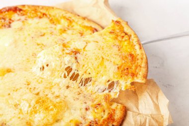Hafif ahşap arka planda lezzetli bir pizza dilimi alıp, yakın plan...