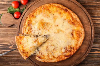 Tahtadan ahşap arka planda lezzetli bir pizza dilimi alıyor.