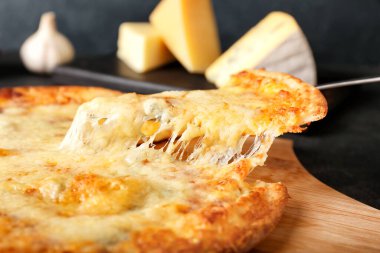 Koyu arkaplandan lezzetli bir pizzayı alıp yakın plan çekiyoruz.