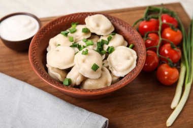 Tahta arka planda lezzetli hamur tatlısı olan bir kase.