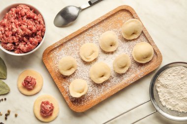 Hafif arkaplanda çiğ hamur köfteleri ve malzemelerle kompozisyon