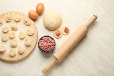 Hafif arkaplanda çiğ hamur köfteleri ve malzemelerle kompozisyon