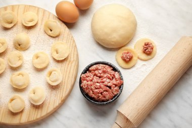 Hafif arkaplanda çiğ hamur köfteleri ve malzemelerle kompozisyon