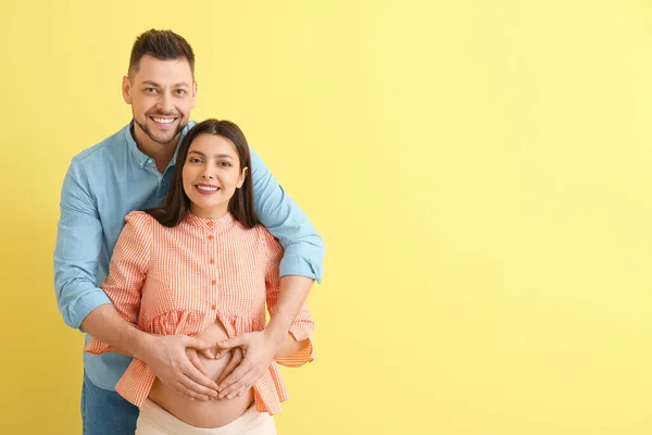 Renkli Arka Planda Güzel Hamile Bir Çift — Stok fotoğraf