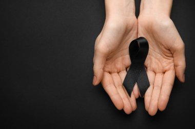 Siyah cenaze kurdeleli bir kadın.