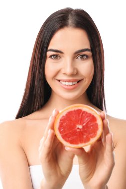 Beyaz arka planda greyfurt olan güzel genç bir kadın.