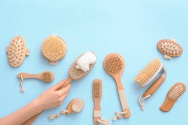 Renkli arka planda farklı masaj fırçaları olan kadın eli