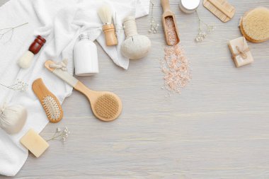 Gri ahşap arka planda masaj fırçaları ve banyo malzemeleri ile kompozisyon