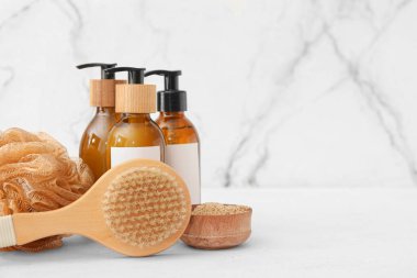 Masaj fırçası ve banyo malzemesi içeren kompozisyon