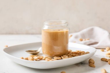 Hafif arka planda fıstık ezmeli kavanoz.