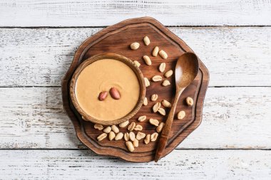 Hafif ahşap arka planda lezzetli fıstık ezmeli tabak.