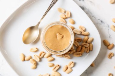 Hafif arka planda fıstık ezmeli kavanoz.