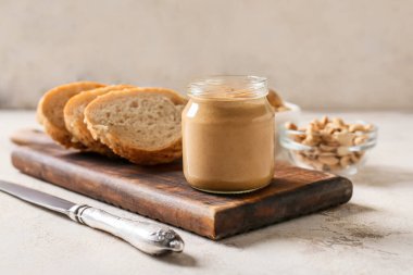 Fıstık ezmeli kavanoz ve arka planda bir parça ekmek.