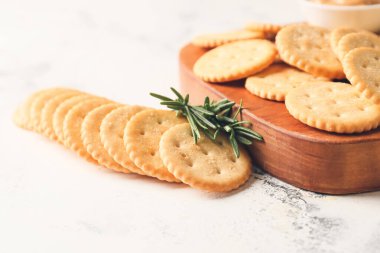 Açık arkaplanda lezzetli krakerler olan tahta