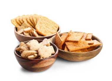 Beyaz arka planda lezzetli krakerler olan kaseler.