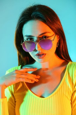 Renkli arka planda güzel bir genç kadının tonlu portresi.