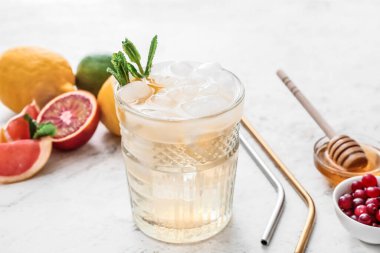 Bir bardak soğuk yeşil çay ve arka planda bulunan malzemeler, yakın plan.