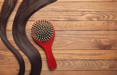 Ahşap arka planda iplikleri olan saç fırçası