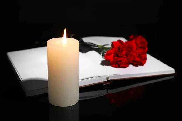 Queimando velas, fita de luto e flores em fundo preto — Foto © serezniy #254548306