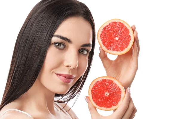 Beyaz arka planda greyfurt olan güzel genç bir kadın.