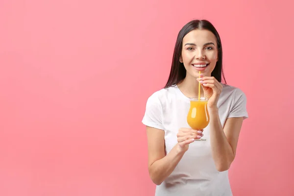 美丽的年轻女子喝橙汁的色泽背景 — 图库照片