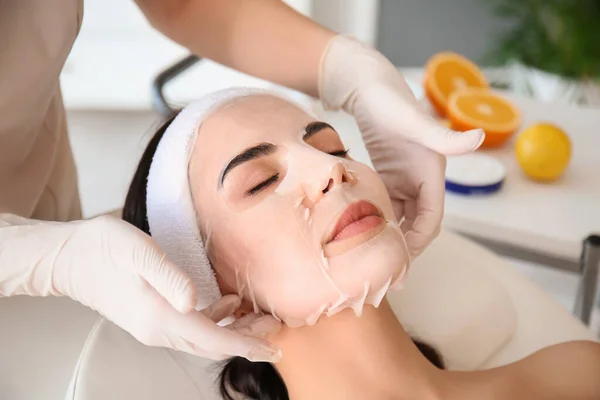 Kosmetolog Tillämpa Sheet Mask Kvinnans Ansikte Skönhetssalong — Stockfoto