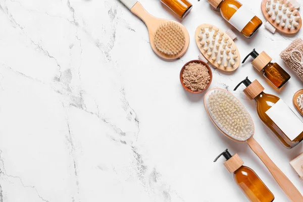 Masaj fırçaları ve hafif arka planda banyo malzemeleri ile kompozisyon