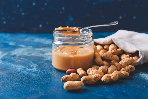 Jar Tasty Peanut Butter Sack Nuts Color Background — Stock Photo, Image