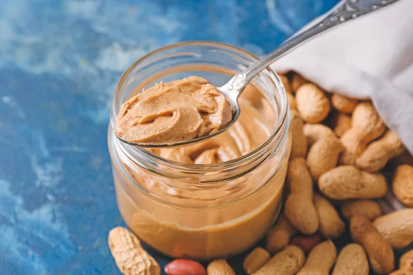 Jar Tasty Peanut Butter Sack Nuts Color Background — Stock Photo, Image