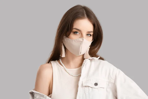 Modische Junge Frau Trägt Maske Auf Grauem Hintergrund — Stockfoto