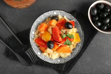 Kuskus ve arka planda sebzeli kase.