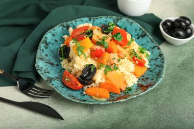 Arka planda kuskus ve sebzeli tabak