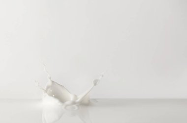 Beyaz arka planda lezzetli süt damlaları