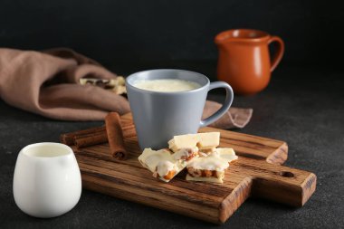 Siyah arka planda sıcak beyaz çikolatalı fincan.