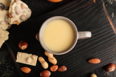 Siyah arka planda sıcak beyaz çikolatalı fincan.