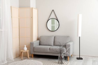 Rahat kanepesi ve aynası olan şık bir oda.