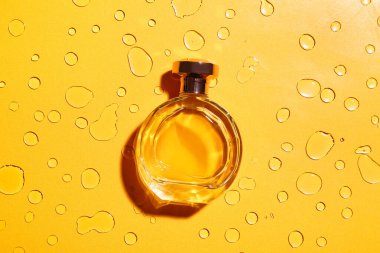 Su damlalarıyla renklendirilmiş bir şişe parfüm.