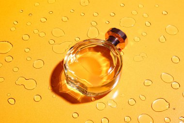 Su damlalarıyla renklendirilmiş bir şişe parfüm.