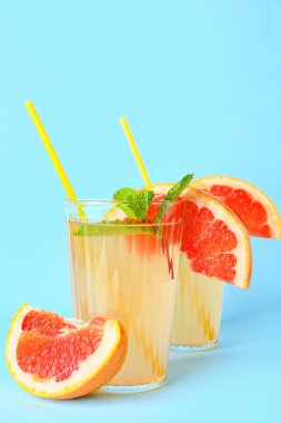 Renkli arkaplanda bir bardak lezzetli greyfurt limonatası.