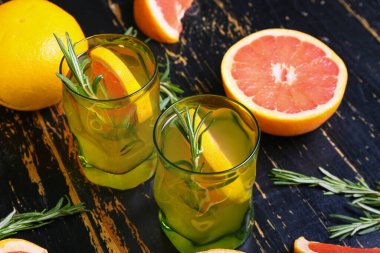 Koyu ahşap arka planda bir bardak lezzetli greyfurt limonatası.